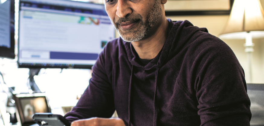 Person Sat At Their Desk Looking At Their Smartphone Portrait (1)